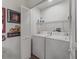 A small but functional laundry room featuring a washer, dryer, and shelving at 2450 Kingstree Pl, The Villages, FL 32162