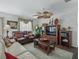 Cozy living room with plush seating, stylish decor, and a ceiling fan for added comfort at 2450 Kingstree Pl, The Villages, FL 32162