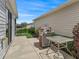 Outdoor patio area with a grill and table with landscaping in a well-maintained backyard at 2450 Kingstree Pl, The Villages, FL 32162
