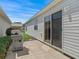 Outdoor patio with a grill and sliding door access to the home under a clear blue sky at 2450 Kingstree Pl, The Villages, FL 32162