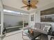 Enjoy outdoor living in this screened in patio with comfortable seating and a ceiling fan at 2450 Kingstree Pl, The Villages, FL 32162