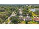 Aerial view of residential neighborhood surrounded by lush trees, near a lake and showcasing beautiful community landscaping at 25129 Riverwalk Dr, Leesburg, FL 34748