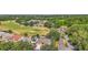 Aerial view of a home nestled in a lush, green landscape, near a golf course and surrounded by mature trees at 25129 Riverwalk Dr, Leesburg, FL 34748