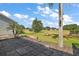 Paver patio extends into a well-manicured backyard with lush landscaping and mature trees at 25129 Riverwalk Dr, Leesburg, FL 34748