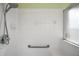 Bathroom featuring an updated shower with white tile, grab bars, and a glass door at 25129 Riverwalk Dr, Leesburg, FL 34748