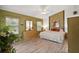 Cozy bedroom features wood floors, a ceiling fan, and natural light from two windows at 25129 Riverwalk Dr, Leesburg, FL 34748