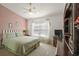 Charming bedroom with pink accent wall, plush carpeting, and white bed frame at 25129 Riverwalk Dr, Leesburg, FL 34748