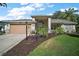 Charming home featuring lush landscaping, manicured lawn, and a welcoming front entrance that offers great curb appeal at 25129 Riverwalk Dr, Leesburg, FL 34748