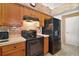 Modern kitchen with sleek black appliances, brick backsplash, and warm wood cabinetry at 25129 Riverwalk Dr, Leesburg, FL 34748