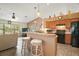 Charming kitchen features a breakfast bar, black appliances, and a brick accent wall at 25129 Riverwalk Dr, Leesburg, FL 34748