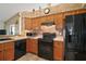 Well-equipped kitchen boasts black appliances, tiled countertops, and ample cabinet space at 25129 Riverwalk Dr, Leesburg, FL 34748