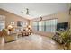 Inviting living room with comfortable seating, a ceiling fan, and natural light from a large window at 25129 Riverwalk Dr, Leesburg, FL 34748