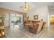 Spacious living room featuring tile flooring, vaulted ceilings, and a seamless transition to the outdoor lanai at 25129 Riverwalk Dr, Leesburg, FL 34748