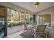 Relaxing screened patio features a ceiling fan, outdoor furniture, and views of the tropical landscaping at 25129 Riverwalk Dr, Leesburg, FL 34748