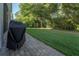 A spacious backyard with lush green grass and a brick-paved patio with a covered grill at 2539 Caithness Way, Clermont, FL 34714