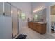Spacious bathroom features double sinks, a walk-in shower, and white tile flooring at 2539 Caithness Way, Clermont, FL 34714