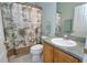 Bathroom with tropical-themed shower curtain, vanity with sink and a toilet at 2539 Caithness Way, Clermont, FL 34714