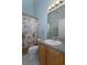 Cozy bathroom features a tropical-themed shower curtain, a toilet, and a single sink vanity at 2539 Caithness Way, Clermont, FL 34714