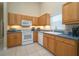 Bright kitchen featuring light wood cabinetry, stainless steel appliances, and white tiled floors at 2539 Caithness Way, Clermont, FL 34714
