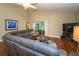 Spacious living room featuring a large gray sectional sofa and hardwood flooring at 2539 Caithness Way, Clermont, FL 34714