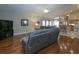 Open-concept living room featuring hardwood floors, a comfortable sectional sofa, and a ceiling fan at 2539 Caithness Way, Clermont, FL 34714
