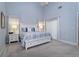 Airy main bedroom with high ceilings, soft carpet, and a king bed dressed with blue and white linens at 2539 Caithness Way, Clermont, FL 34714