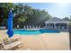 Community pool area with clear blue water, lounge chairs, and umbrellas, perfect for relaxing and enjoying the outdoors at 2539 Caithness Way, Clermont, FL 34714