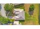 Drone eye view of a tan house with a tile roof, green grass, and a nice lawn at 2641 Meadow View Ct, Kissimmee, FL 34746