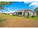 Backyard featuring a well-maintained lawn and the rear of the house with a screened-in patio at 2641 Meadow View Ct, Kissimmee, FL 34746