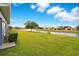 Beautiful backyard featuring a lush green lawn that gently slopes down to a tranquil pond at 2641 Meadow View Ct, Kissimmee, FL 34746