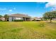 View of the backyard with lush grass, a screened in lanai, and the exterior of the house at 2641 Meadow View Ct, Kissimmee, FL 34746