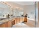 Bright bathroom with dual sinks, soaking tub, and glass-enclosed shower at 2641 Meadow View Ct, Kissimmee, FL 34746