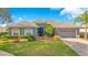 Charming single-story home with well-manicured lawn, tiled roof, mature landscaping, and a two-car garage at 2641 Meadow View Ct, Kissimmee, FL 34746