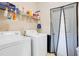 Laundry room featuring a side-by-side washer and dryer, wire shelving and a door leading to the outside at 2641 Meadow View Ct, Kissimmee, FL 34746