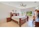 Main bedroom with ceiling fan, tile floors, and large windows overlooking backyard at 2641 Meadow View Ct, Kissimmee, FL 34746