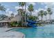 Resort-style pool with a water slide, surrounded by tropical landscaping and lounge chairs at 2641 Meadow View Ct, Kissimmee, FL 34746