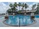Beautiful pool area with lush landscaping and a view of the community clubhouse at 2641 Meadow View Ct, Kissimmee, FL 34746