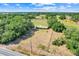 Expansive property showcasing a fenced yard, lush trees, and a home with a green roof amid a tranquil landscape at 274 W Kings Hwy, Center Hill, FL 33514
