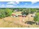 Aerial view of charming home featuring a green roof, fenced yard, pool, and lush greenery, surrounded by serene nature at 274 W Kings Hwy, Center Hill, FL 33514
