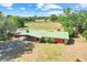 Stunning aerial view of the home with a green metal roof and sprawling green pastures at 274 W Kings Hwy, Center Hill, FL 33514