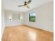 Cozy bedroom featuring light wood floors, a ceiling fan, and a large window for ample sunlight at 274 W Kings Hwy, Center Hill, FL 33514
