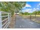 Long driveway leading to a red house with a green roof, surrounded by open pastures at 274 W Kings Hwy, Center Hill, FL 33514