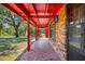 Inviting front porch with mosaic-style flooring, brick accents, and red support columns at 274 W Kings Hwy, Center Hill, FL 33514
