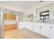 Updated kitchen with white cabinets, granite counters, tile floors, stainless appliances, and an open view to the dining room at 274 W Kings Hwy, Center Hill, FL 33514