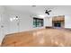 Bright living room with hardwood floors, a brick fireplace, and a large picture window at 274 W Kings Hwy, Center Hill, FL 33514