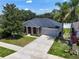 Aerial view of a well-maintained home with a two-car garage and landscaped yard at 31920 Parkdale Dr, Leesburg, FL 34748