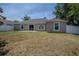 Backyard view of a home featuring a patio and large, green space, ideal for outdoor living and activities at 31920 Parkdale Dr, Leesburg, FL 34748
