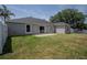 An outdoor patio in the private backyard with well-maintained lawn and sliding glass doors at 31920 Parkdale Dr, Leesburg, FL 34748
