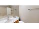 Bright bathroom featuring a single sink vanity, toilet, and shower with white shower curtain at 31920 Parkdale Dr, Leesburg, FL 34748