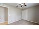 Well-lit bedroom with closet, neutral walls, carpet floors, and a view of the outside through a window at 31920 Parkdale Dr, Leesburg, FL 34748